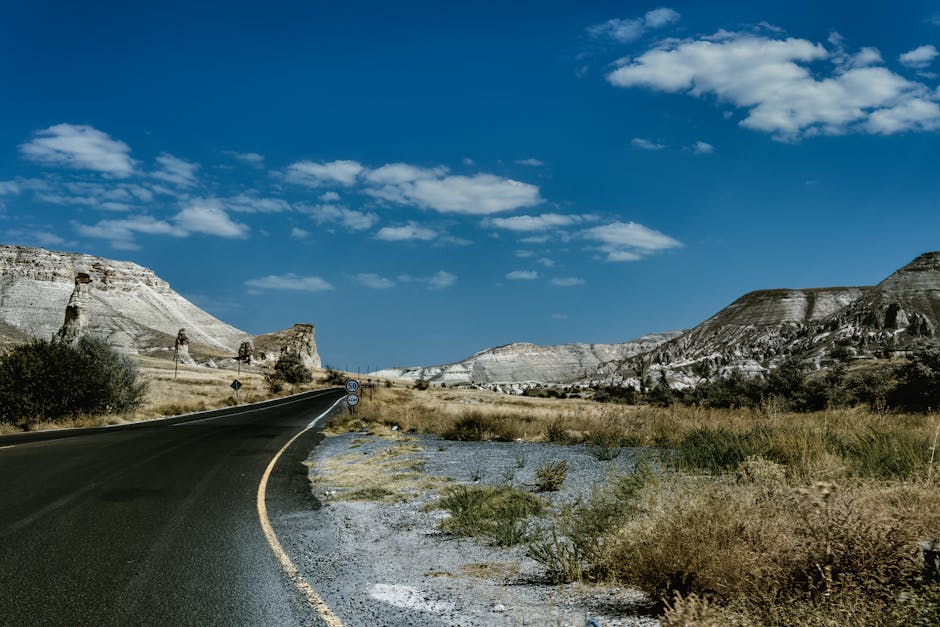 A scenic drive through Cappadocia's stunning rocky terrain on a clear day.