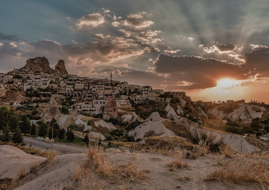 Stunning sunset view of Cappadocia, Turkey with unique rock formations and historic architecture.